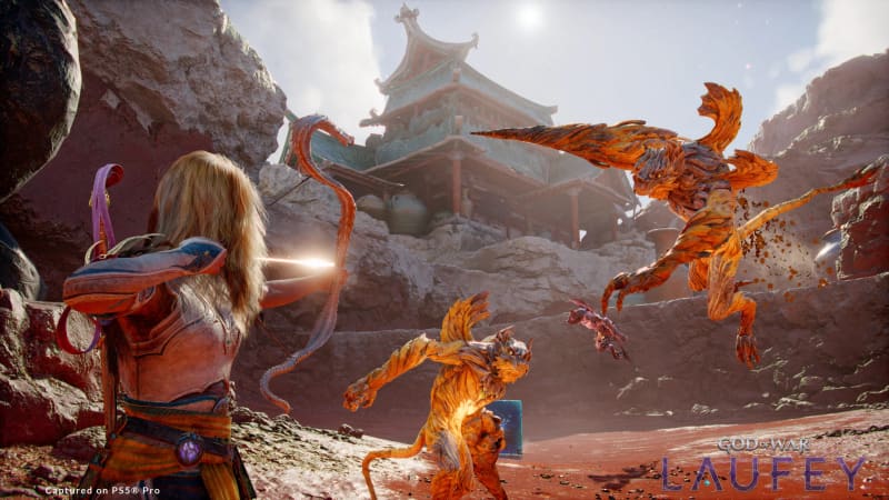 God of War Laufey screenshot of a warrior drawing a bow at two fiery beasts in front of a pagoda