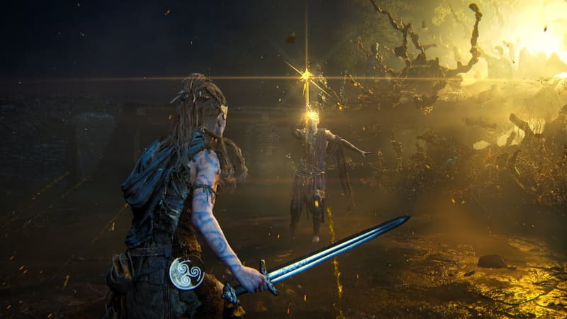 Senua holds a sword in a dark landscape with golden light
